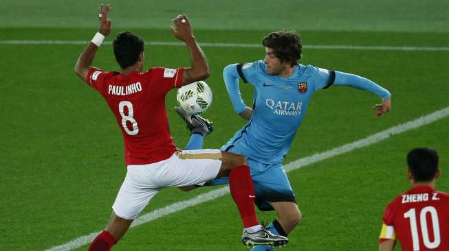 Pemain Barcelona Sergi Roberto berebut bola dengan pemain Guangzhou Paulinho (17/12) [Reuters/Yuya Shino]