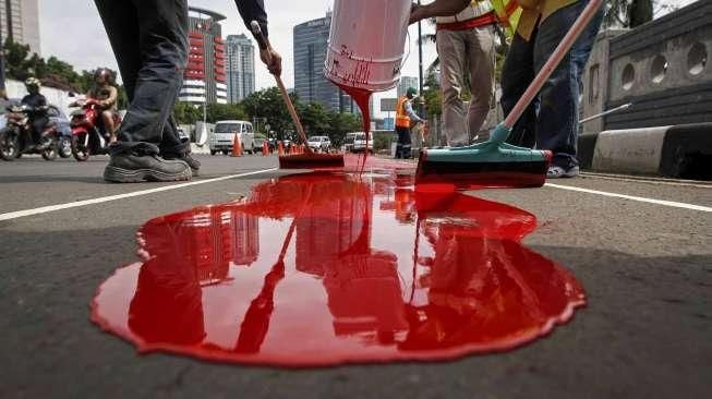 Pekerja melakukan pengecatan jalur bus Transjakarta di flyover Kuningan, Jalan HR Rasuna Said, Kuningan, Jakarta, Minggu (20/12/2015). [Suara.com/Kurniawan Mas'ud]