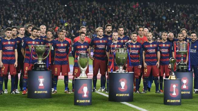 Para pemain Barcelona berpose dengan lima trofi yag mereka raih di 2015. Reuters/Stringer