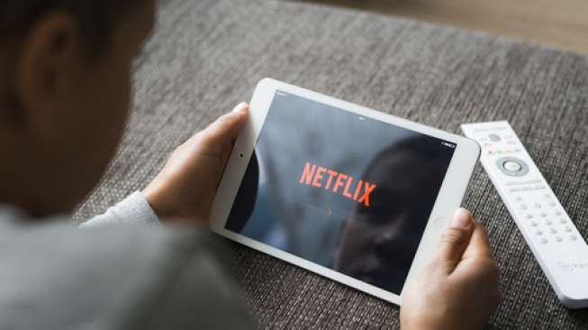 Seorang pelanggan sedang mengakses Netflix melalui komputer tablet (Shutterstock).