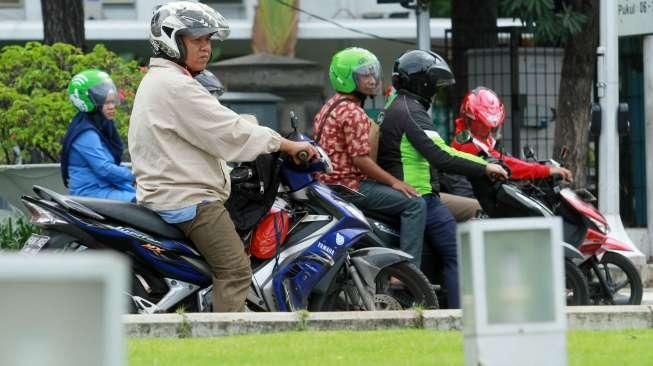 Pengendara bermotor melintas di kawasan silang Monas, Jakarta Pusat, Rabu (13/1).