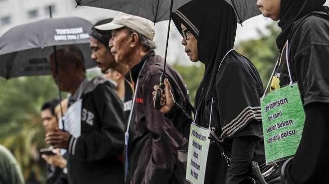 Anggota Jaringan Solidaritas Korban untuk Keadilan membagikan bunga kepada personel polisi dalam acara refleksi 