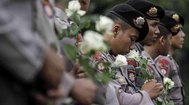 Anggota Jaringan Solidaritas Korban untuk Keadilan membagikan bunga kepada personel polisi dalam acara refleksi 