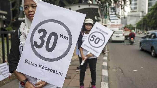 Sejumlah aktivis dari Koalisi Pejalan Kaki menggelar aksi peringatan Hari Pejalan Kaki di halte Tugu Tani, Jakarta, Jumat (22/1/2016). [Suara.com/Kurniawan Mas'ud]