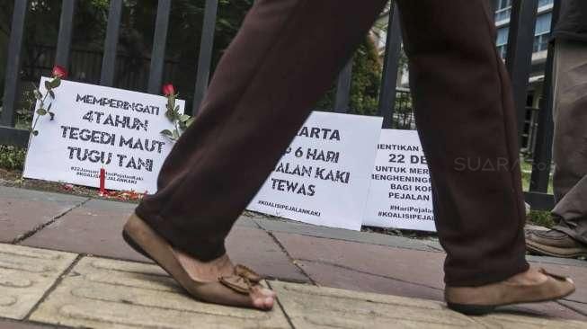 Sejumlah aktivis dari Koalisi Pejalan Kaki menggelar aksi peringatan Hari Pejalan Kaki di halte Tugu Tani, Jakarta, Jumat (22/1/2016). [Suara.com/Kurniawan Mas'ud]