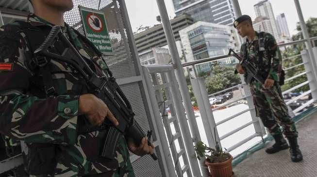 Sejumlah personel TNI AD tampak berjaga di jembatan penyeberangan orang (JPO) di kawasan Bundaran HI, Jakarta, Sabtu (5/3/2016), terkait pengamanan KTT Luar Biasa OKI. [Suara.com/Kurniawan Mas'ud]