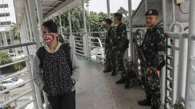 Sejumlah personel TNI AD tampak berjaga di jembatan penyeberangan orang (JPO) di kawasan Bundaran HI, Jakarta, Sabtu (5/3/2016), terkait pengamanan KTT Luar Biasa OKI. [Suara.com/Kurniawan Mas'ud]