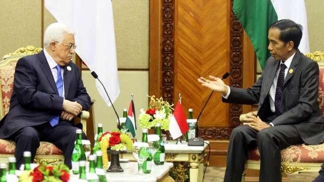 Presiden Joko Widodo (kiri) dan Presiden Palestina Mahmoud Abbas tersenyum hangat saat bertemu dalam acara KTT Luar Biasa Organisasi Kerjasama Islam (OKI) di Jakarta Convention Center (JCC) Senayan, Jakarta, Minggu (6/3).