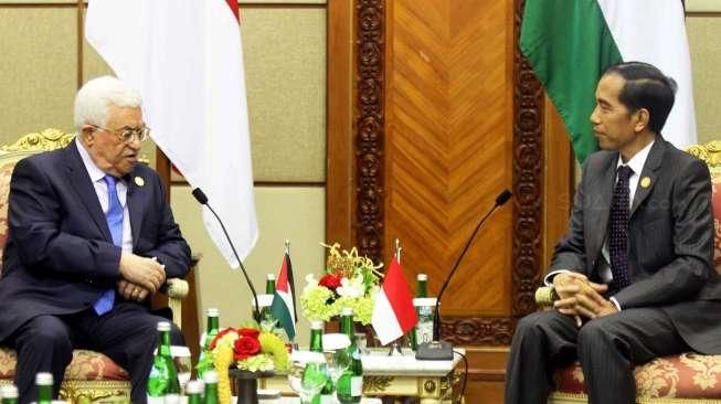 Presiden Joko Widodo (kiri) dan Presiden Palestina Mahmoud Abbas tersenyum hangat saat bertemu dalam acara KTT Luar Biasa Organisasi Kerjasama Islam (OKI) di Jakarta Convention Center (JCC) Senayan, Jakarta, Minggu (6/3).