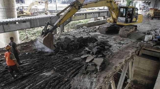 Petugas dibantu alat berat melakukan pembongkaran jembatan permanen yang menghubungkan batas wilayah Cawang-Cililitan di Kalibata, Jakarta, Senin (7/3/2016). [Suara.com/Kurniawan Mas'ud]