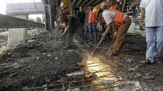 Petugas dibantu alat berat melakukan pembongkaran jembatan permanen yang menghubungkan batas wilayah Cawang-Cililitan di Kalibata, Jakarta, Senin (7/3/2016). [Suara.com/Kurniawan Mas'ud]