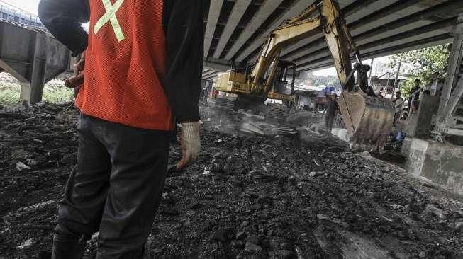 Petugas dibantu alat berat melakukan pembongkaran jembatan permanen yang menghubungkan batas wilayah Cawang-Cililitan di Kalibata, Jakarta, Senin (7/3/2016). [Suara.com/Kurniawan Mas'ud]