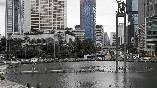 Pekerja memasang penyanggah Monumen Selamat Datang di kolam Bundaran HI, di Jakarta, Rabu (23/3).