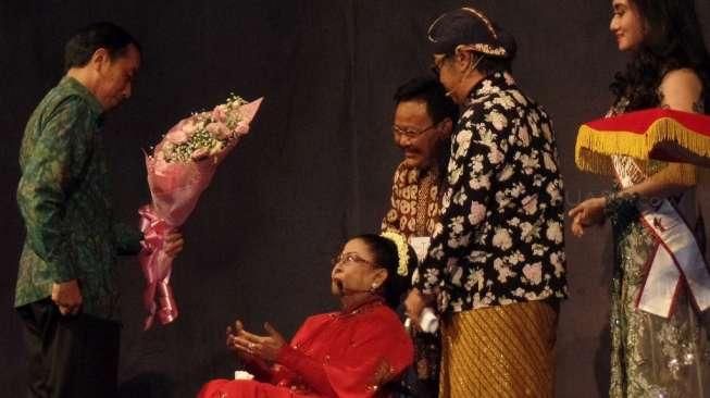 Presiden Joko Widodo memberikan tanda tresno (cinta) kepada penyanyi legendaris keroncong, Waljinah, ‎di Taman Ismail Marzuki, Jakarta, Jumat (1/4/2016) malam. [Suara.com/Erick Tanjung]