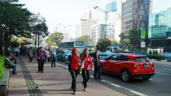 Sejumlah pejalan kaki tampak berjalan di trotoar kawasan Jalan Sudirman, Jakarta, Selasa (19/4/2016). [Suara.com/Oke Atmaja]