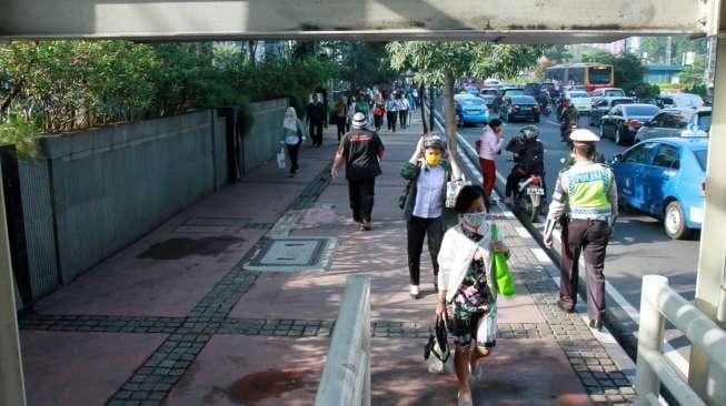 Sejumlah pejalan kaki tampak berjalan di trotoar kawasan Jalan Sudirman, Jakarta, Selasa (19/4/2016). [Suara.com/Oke Atmaja]