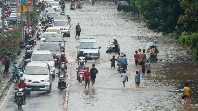 Suasana genangan air dan kondisi lalu lintas di kawasan Jalan Gunung Sahari Raya, Pademangan, Sawah Besar, Jakarta, Kamis (21/4/2016). [Suara.com/Oke Atmaja]