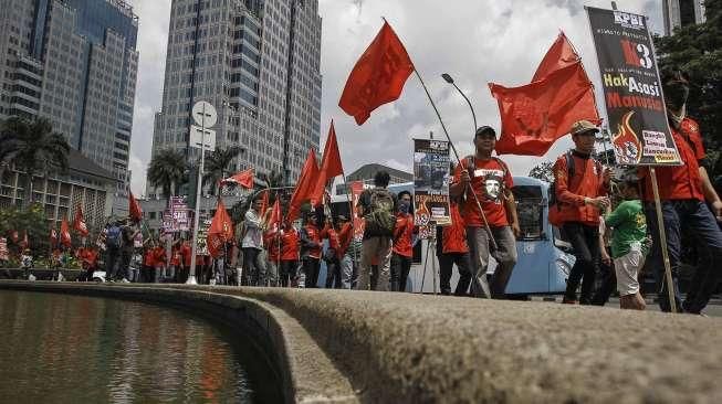 Komite Persiapan Konfederasi Persatuan Buruh Indonesia (KP-KPBI) melakukan aksi unjuk rasa di kawasan Bundaran Patung Kuda, Jakarta, Kamis (28/4/2016). [Suara.com/Kurniawan Mas'ud]