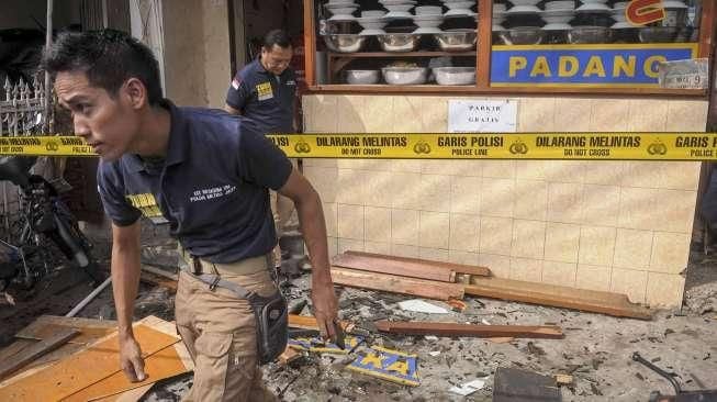 Petugas kepolisian melakukan pemeriksaan di lokasi ledakan yang terjadi di rumah makan nasi Padang kawasan Slipi, Jakarta, Selasa (24/5). [Suara.com/Kurniawan Mas'ud]