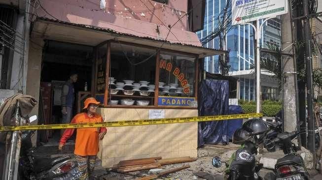 Petugas kepolisian melakukan pemeriksaan di lokasi ledakan yang terjadi di rumah makan nasi Padang kawasan Slipi, Jakarta, Selasa (24/5). [Suara.com/Kurniawan Mas'ud]