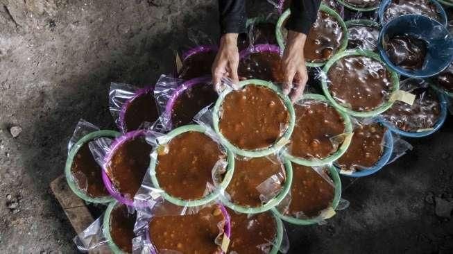 Pekerja memasak adonan dodol di rumah industri olahan dodol Betawi di kawasan Pasar Minggu, Jakarta, Kamis (23/6).[Suara.com/Kurniawan Mas'ud]