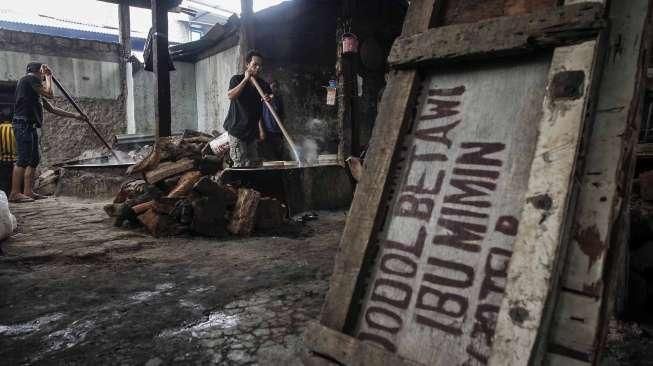 Pekerja memasak adonan dodol di rumah industri olahan dodol Betawi di kawasan Pasar Minggu, Jakarta, Kamis (23/6).[Suara.com/Kurniawan Mas'ud]