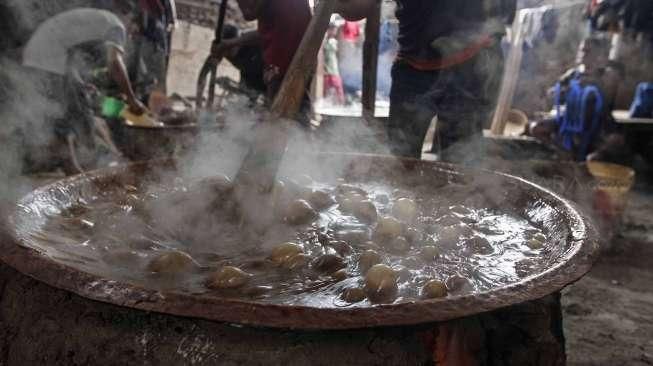 Pekerja memasak adonan dodol di rumah industri olahan dodol Betawi di kawasan Pasar Minggu, Jakarta, Kamis (23/6).[Suara.com/Kurniawan Mas'ud]