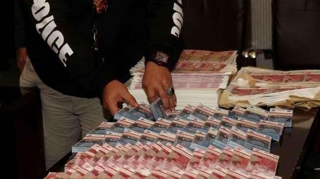 Polisi berhasil mengamankan sedikitnya 6 orang tersangka beserta uang palsu tercetak setara Rp.7 milyar, dari sejumlah tempat di Jakarta dan Jawa Tengah. [Suara.com/Oke Atmaja]