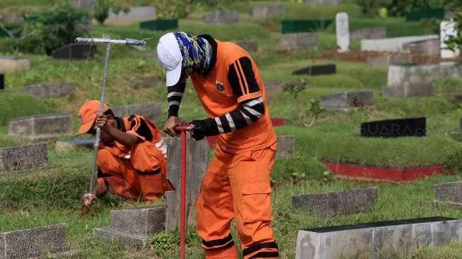 Pekerja Sudin Pertamanan dan Pemakaman Jakarta membuat lubang biopori di TPU Karet Bivak, Tanah Abang, Jakarta Pusat, Jumat (22/7). [Suara.com/Oke Atmaja]