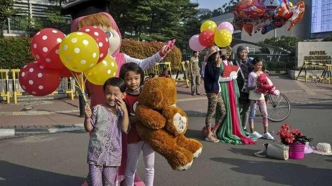 Relawan yang tergabung dalam Lentera Anak Indonesia menggelar aksi simpatik di Bundaran HI, Jakarta, Minggu (24/7/2016). [Suara.com/Kurniawan Mas'ud]