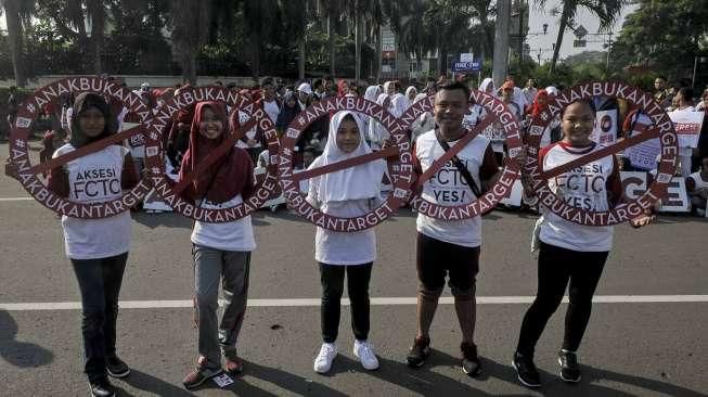 Relawan yang tergabung dalam Lentera Anak Indonesia menggelar aksi simpatik di Bundaran HI, Jakarta, Minggu (24/7/2016). [Suara.com/Kurniawan Mas'ud]