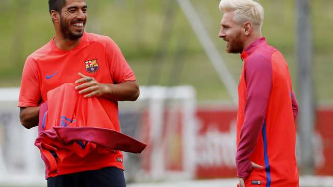 Pemain BarceLionel Messi sedang berbicara dengan Luis Suarez saat latihan. Reuters / Darren Staples Livepic