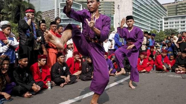 Sejumlah anak dan orang dewasa memperagakan atraksi silat dalam acara Lebaran Pendekar Betawi di Bundaran Hotel Indonesia (HI), Jakarta, Minggu (7/8/2016). [Suara.com/Kurniawan Mas'ud]