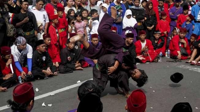 Sejumlah anak dan orang dewasa memperagakan atraksi silat dalam acara Lebaran Pendekar Betawi di Bundaran Hotel Indonesia (HI), Jakarta, Minggu (7/8/2016). [Suara.com/Kurniawan Mas'ud]