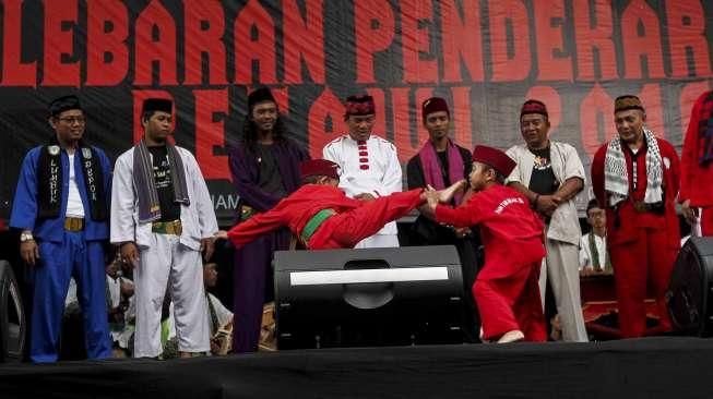 Sejumlah anak dan orang dewasa memperagakan atraksi silat dalam acara Lebaran Pendekar Betawi di Bundaran Hotel Indonesia (HI), Jakarta, Minggu (7/8/2016). [Suara.com/Kurniawan Mas'ud]