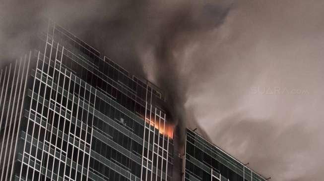 Kobaran api dan upaya evakuasi dalam kebakaran sebuah proyek gedung Swiss-Belhotel di kawasan Kelapa Gading, Jakarta, Minggu (7/8/2016). [Suara.com/Kurniawan Mas'ud]