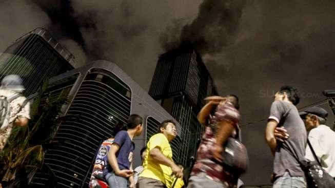 Kobaran api dan upaya evakuasi dalam kebakaran sebuah proyek gedung Swiss-Belhotel di kawasan Kelapa Gading, Jakarta, Minggu (7/8/2016). [Suara.com/Kurniawan Mas'ud]