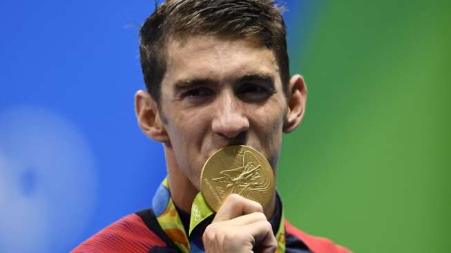 Perenang AS, Michael Phelps, mencium medali emas yang didapatnya di nomor estafet 4x100 meter gaya bebas putra Olimpiade 2016 Rio de Janeiro, (7/8) [AFP/Gabriel Bouys]