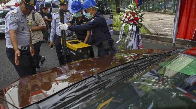 Petugas Dishub DKI Jakarta melakukan pemeriksaan uji KIR khusus kendaraan sewa berbasis transportasi online di kawasan Monas, Jakarta, Senin (15/8/2016). [Suara.com/Kurniawan Mas'ud]