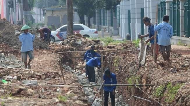 Sejumlah pekerja tampak menyelesaikan pembangunan trotoar di kawasan Senayan, Jakarta, Sabtu (20/8/2016). [Suara.com/Oke Atmaja]