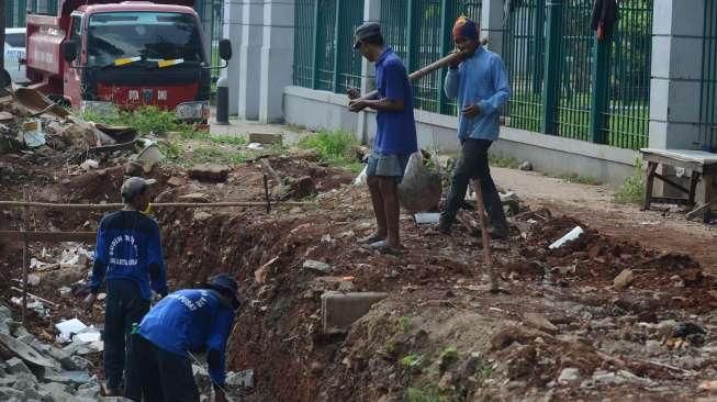 Sejumlah pekerja tampak menyelesaikan pembangunan trotoar di kawasan Senayan, Jakarta, Sabtu (20/8/2016). [Suara.com/Oke Atmaja]