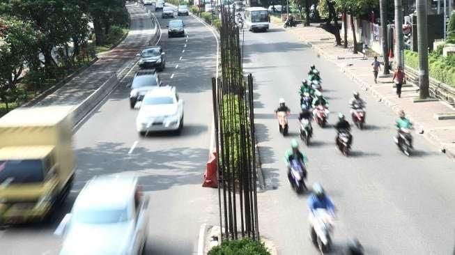 Sejumlah kendaraan tampak melintas di samping deretan tiang bekas proyek monorail yang terhenti, di Jalan HR Rasuna Said, Jakarta, Sabtu (20/8/2016). [Suara.com/Oke Atmaja]