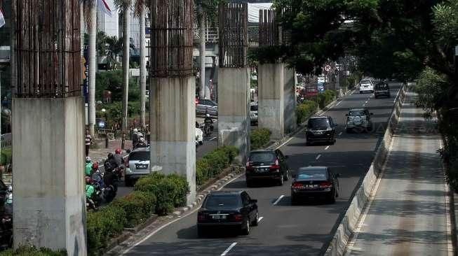 Sejumlah kendaraan tampak melintas di samping deretan tiang bekas proyek monorail yang terhenti, di Jalan HR Rasuna Said, Jakarta, Sabtu (20/8/2016). [Suara.com/Oke Atmaja]