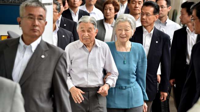 Kaisar Jepang, Akihito, berjalan bersama istrinya Michiko sebelum memasuki kereta cepat, Sabtu (20/8/2016), saat hendak berangkat dari Stasiun Tokyo, guna menjalani kunjungan ke Prefektur Nagano dan Gunma. [Kazuhiro Nogi/AFP]