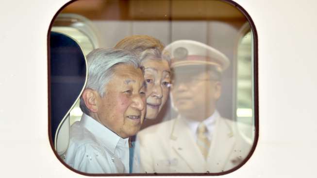 Kaisar Jepang, Akihito, bersama istrinya Michiko, tersenyum dari dalam kereta cepat, Sabtu (20/8/2016), saat hendak berangkat dari Stasiun Tokyo, guna menjalani kunjungan ke Prefektur Nagano dan Gunma. [Kazuhiro Nogi/AFP]