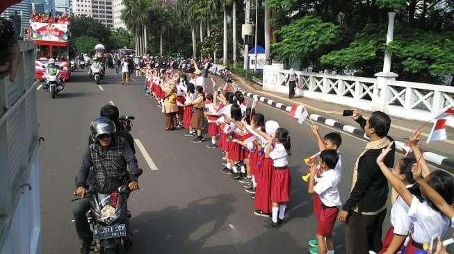 Dari Murid SD Sampai Pegawai Kantoran, Sambut Arak-arakan Owi Cs