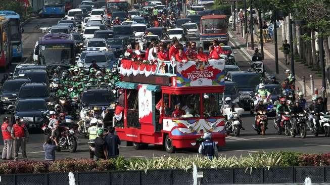 Sejumlah atlet yang mengikuti arak-arakan dengan menaiki bus Bandros menuju Istana Negara, terlihat melintasi kawasan Jalan MH Thamrin, Jakarta, Rabu (24/8/2016). [Suara.com/Oke Atmaja]