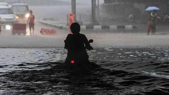 Sejumlah kendaraan tampak terjebak banjir di kolong jembatan kawasan Dukuh Atas, Jakarta, Selasa (30/8/2016). [Suara.com/Kurniawan Mas'ud]