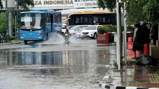 Beberapa kendaraan tampak melintasi jalanan yang tergenang air di Jalan Agus Salim, kawasan Menteng, Jakarta Pusat, Selasa (30/8/2016). [Suara.com/Oke Atmaja]