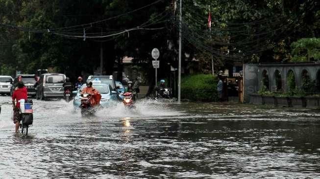 Beberapa kendaraan tampak melintasi jalanan yang tergenang air di Jalan Agus Salim, kawasan Menteng, Jakarta Pusat, Selasa (30/8/2016). [Suara.com/Oke Atmaja]